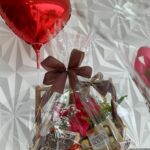 Cesta de aniversário com arranjo de rosas, chocolates e balão
